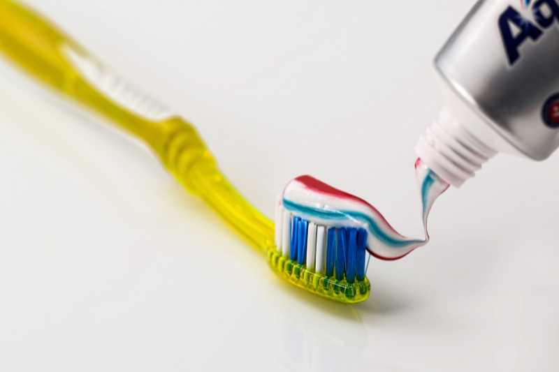 putting toothpaste on toothbrush